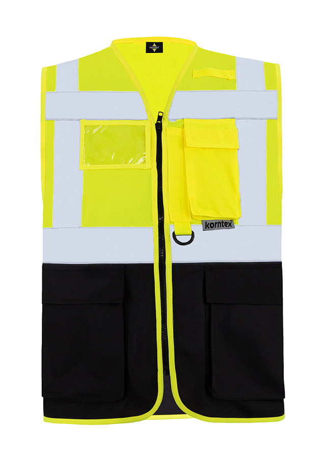 Construction worker in orange Korntex multifunctional safety vest and helmet communicates via radio on a construction site