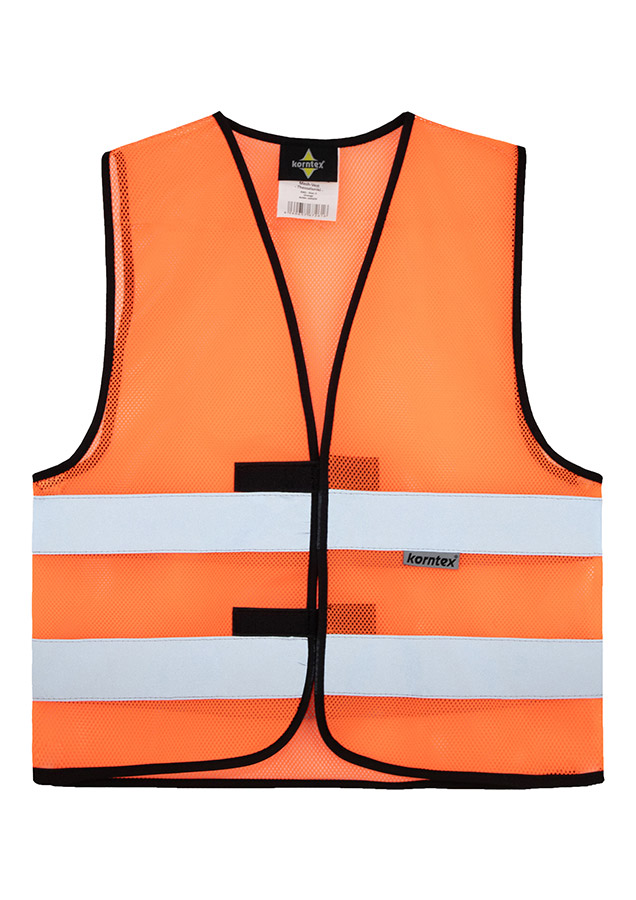 Adult construction worker stands on a building site in a yellow Korntex mesh safety vest and yellow helmet holding tools