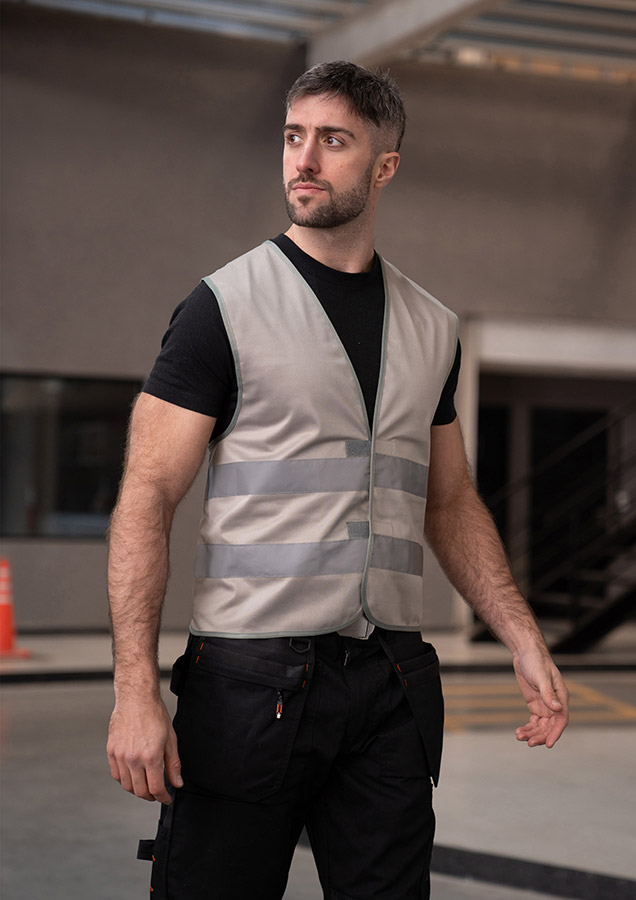Adult in yellow Korntex safety vest in an industrial environment