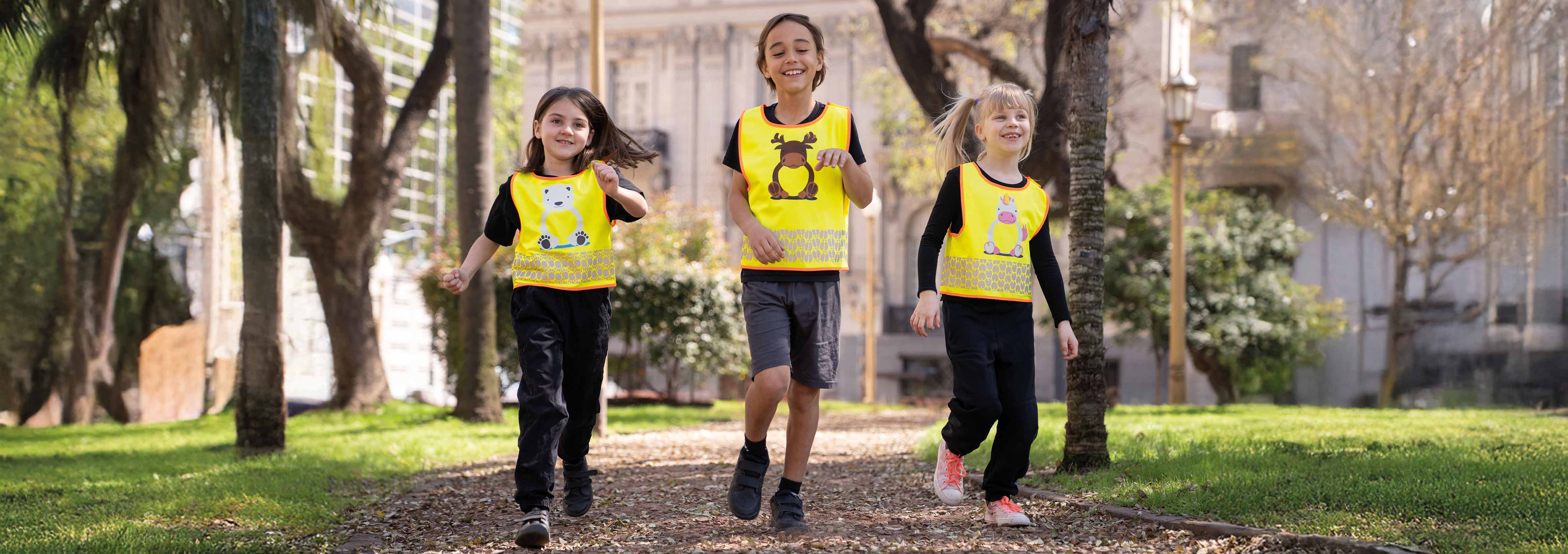 Spielende Kinder mit gelben bedruckbaren Kinderwarnwesten mit Motiv