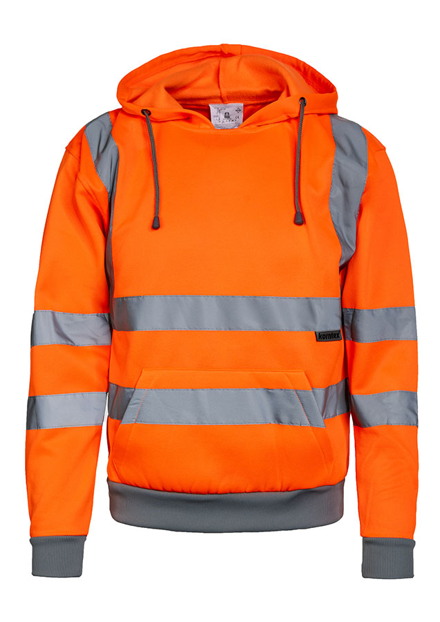 Adult man stands in signal yellow Korntex hi-vis hoodie with reflective stripes and black work trousers in an industrial environment