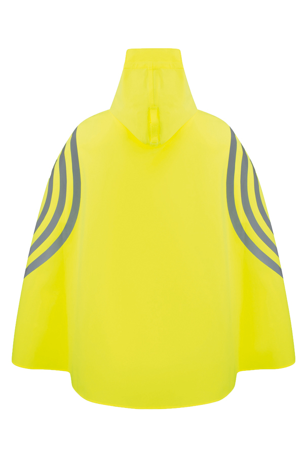 Woman wearing a yellow hooded rain poncho while standing next to a bicycle on a cycle path