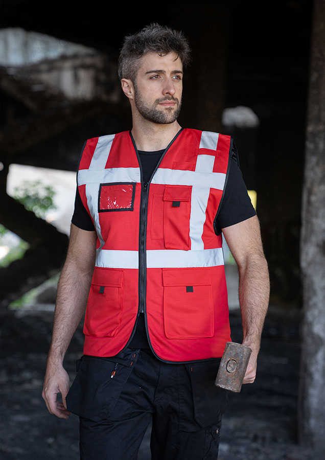 Adult in signal yellow, lined Korntex safety vest with zip fastener in an industrial environment