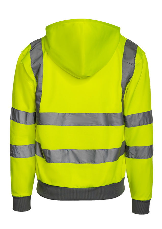 Adult man stands in signal yellow Korntex hi-vis hoodie with reflective stripes and black work trousers in an industrial environment