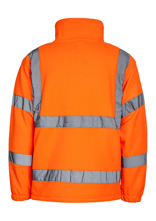 Adult man wearing a signal orange Korntex hi-vis fleece jacket with reflective stripes walking in front of an industrial buil