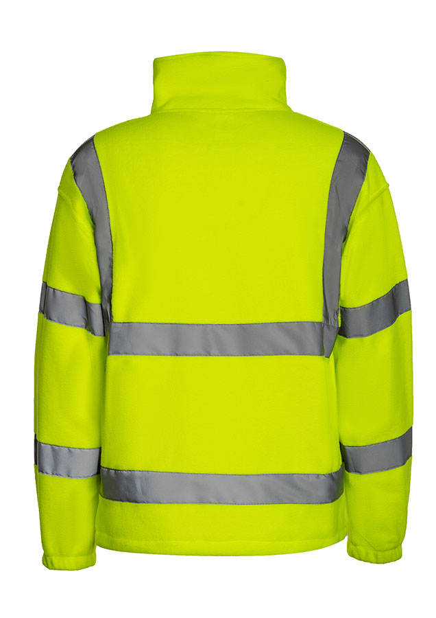 Adult man wearing a signal orange Korntex hi-vis fleece jacket with reflective stripes walking in front of an industrial buil