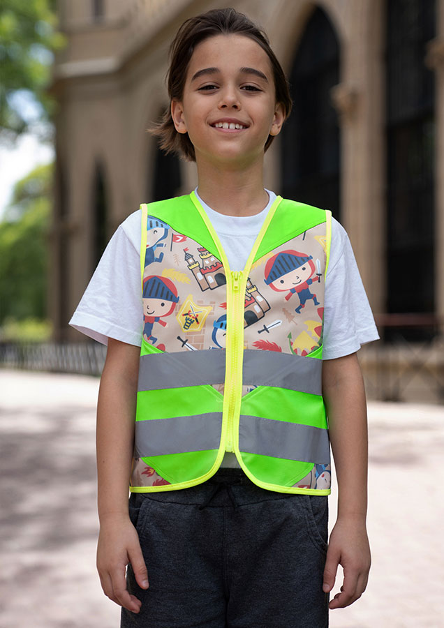 Child in a neon green Korntex safety vest with knight pattern in a park