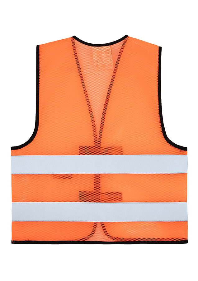 Adult construction worker stands on a building site in a yellow Korntex mesh safety vest and yellow helmet holding tools