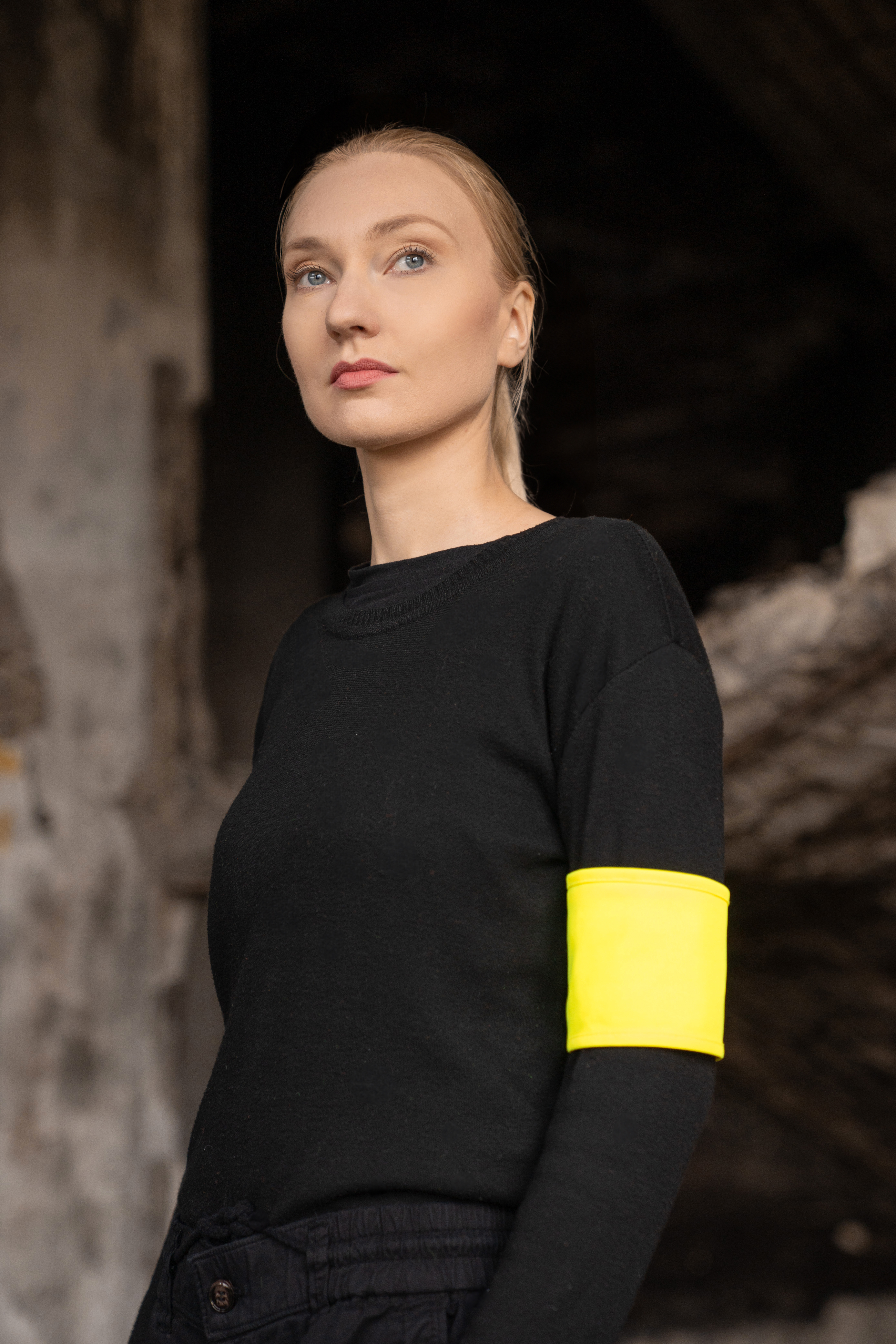 Portrait of a young woman with a reflective yellow Korntex bracelet in an industrial ruin