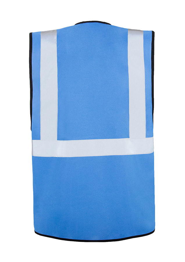 A woman wears a pink Korntex safety vest with reflective stripes in a warehouse