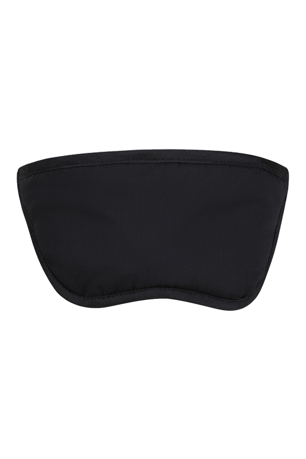 Woman wearing a black Korntex sleep mask while sitting on a couch